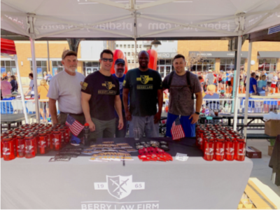 Four men standing behind a Berry Law merchandise table