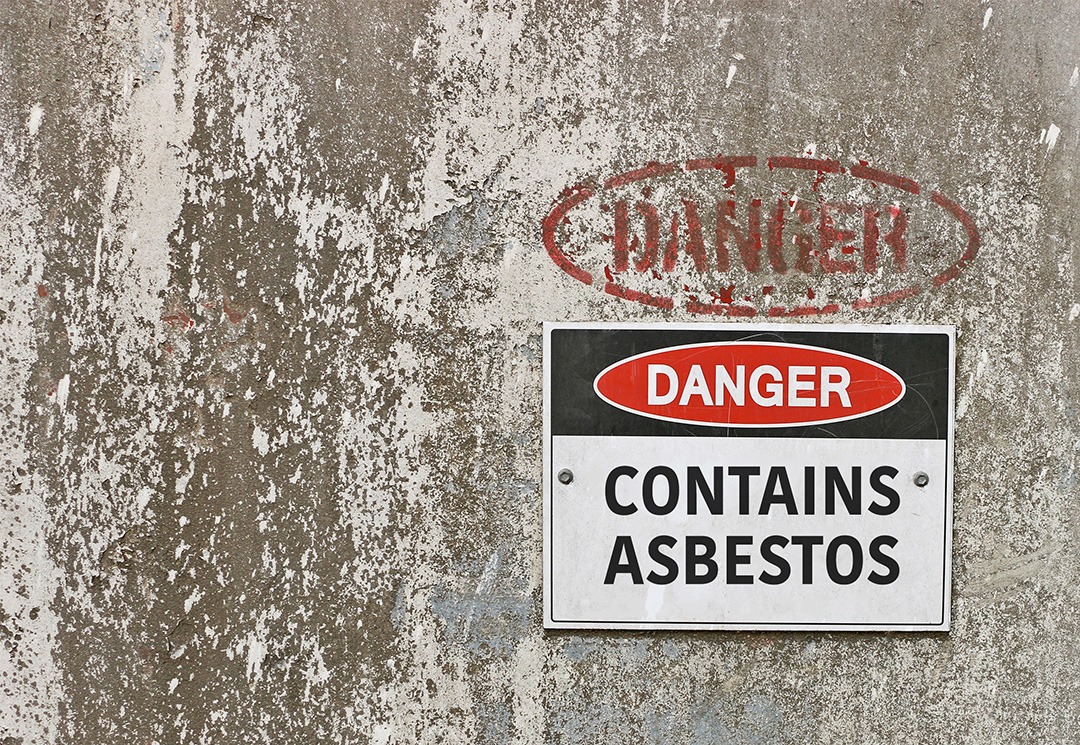 cement wall with "danger contains asbestos" sign on it